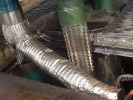 Flexible metal hose with worn stainless braid for overloading in a compressor